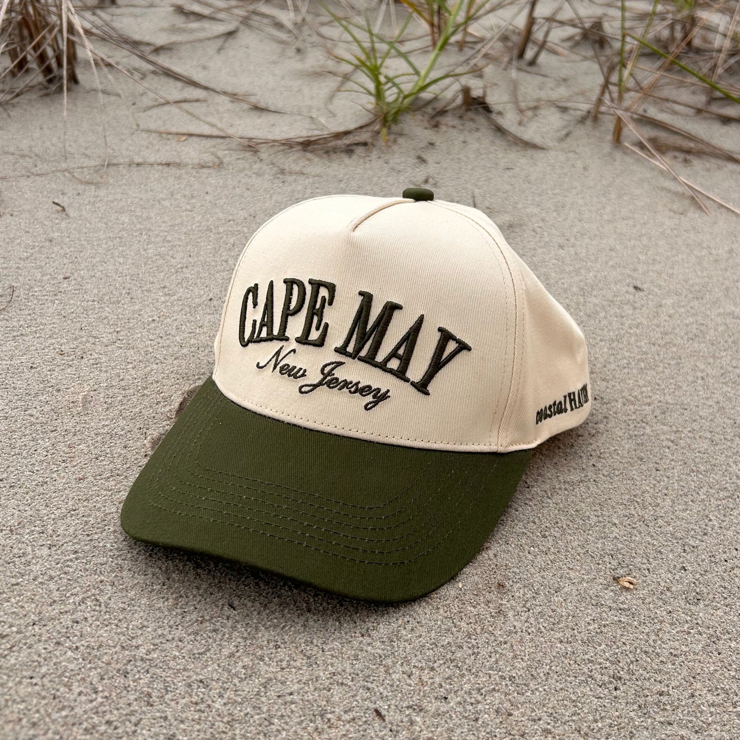 Beige cap with 'Cape May New Jersey' text on a sandy beach